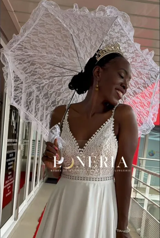 Mariée en robe Lunéria sous une ombrelle de dentelle, en extérieur
